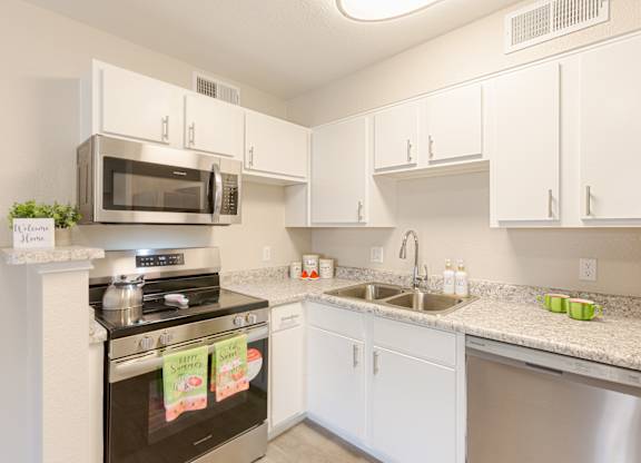 A kitchen with white cabinets and a black stove top.