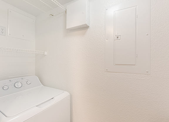 A white washing machine in a small laundry room.