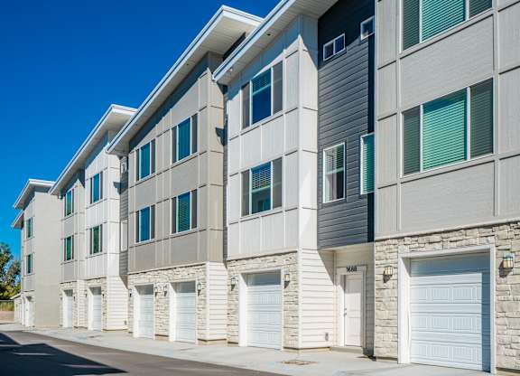 the exterior of a building with white garage doors