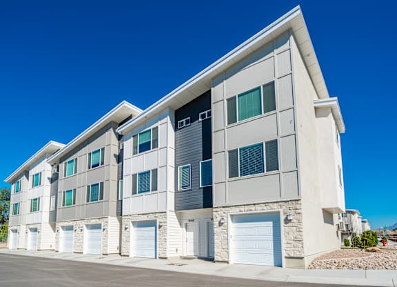 an apartment building with white doors and a blue sky