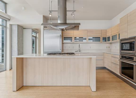 A modern kitchen with a large island and stainless steel appliances.
