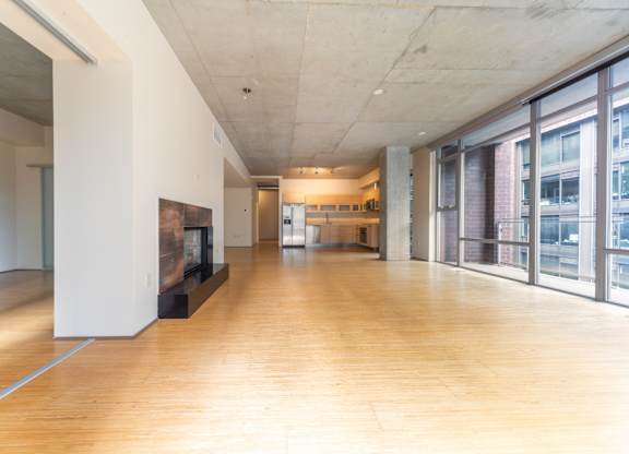 A long hallway with a fireplace and a white wall on the left.