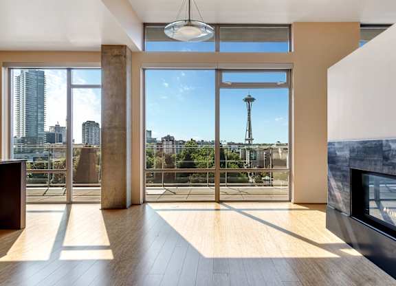 A modern living room with a view of the cityscape outside the large windows.