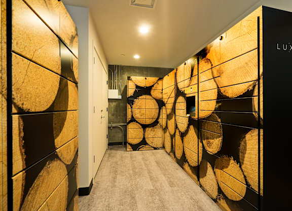 A hallway with a wall of wood logs on the side.