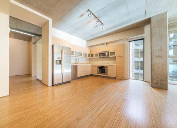 A kitchen with wooden floors and stainless steel appliances.