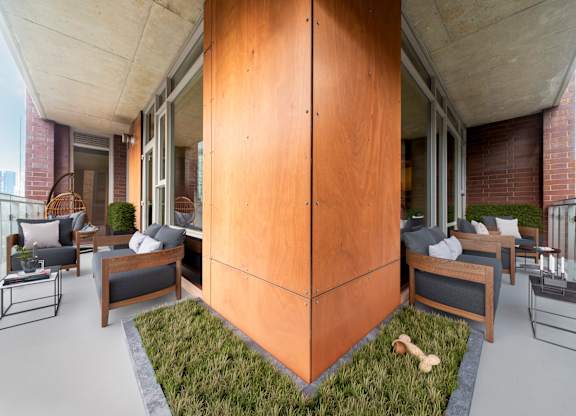 A modern balcony with a wooden floor and furniture.