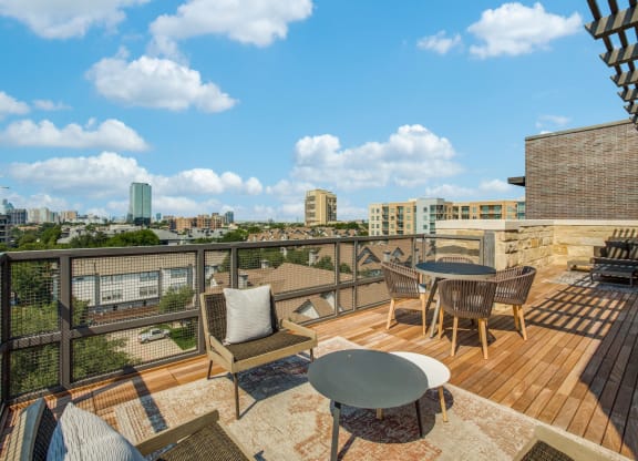 a balcony with a table and chairs and a view of the city