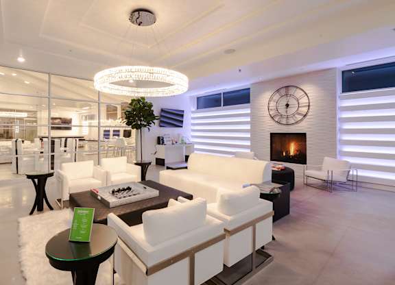 A modern living room with a fireplace and a large clock on the wall.
