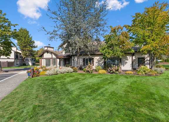 A house with a green lawn and trees in front. at Saratoga, Everett, WA