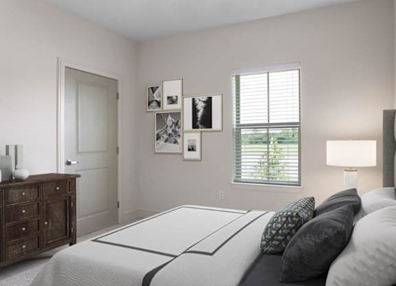 A bedroom with a bed, nightstand, and pictures on the wall.