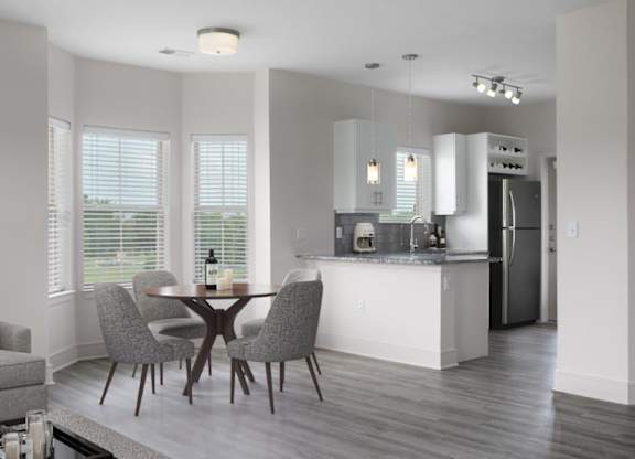 A modern kitchen with a dining table and chairs.