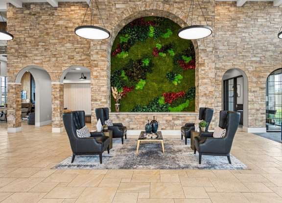 the lobby of a hotel with a large wall mural of plants in a lobby