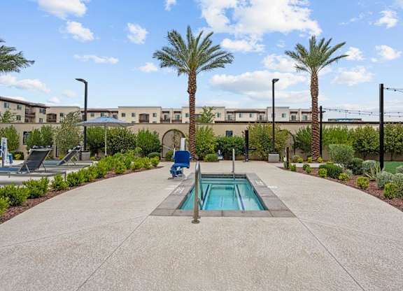 a small pool sits in the middle of a patio with palm trees