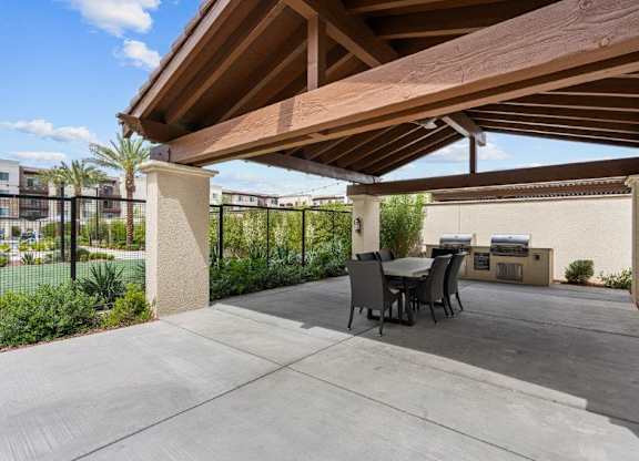 a covered patio with a table and chairs