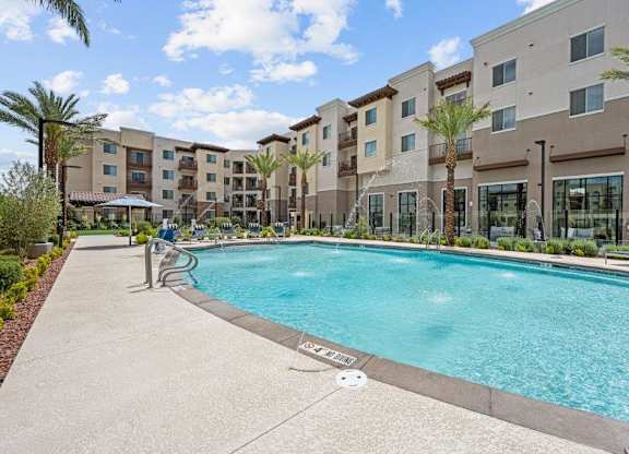 a swimming pool with an apartment building in the background