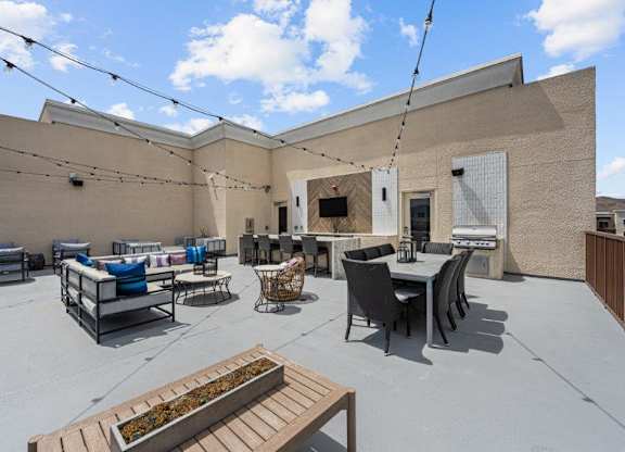 the patio of the building has a table and chairs and a fireplace