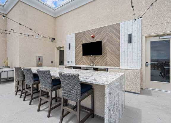 a kitchen with a marble counter top and a group of chairs