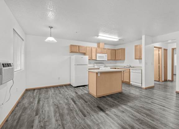 A kitchen with white appliances and wooden cabinets.