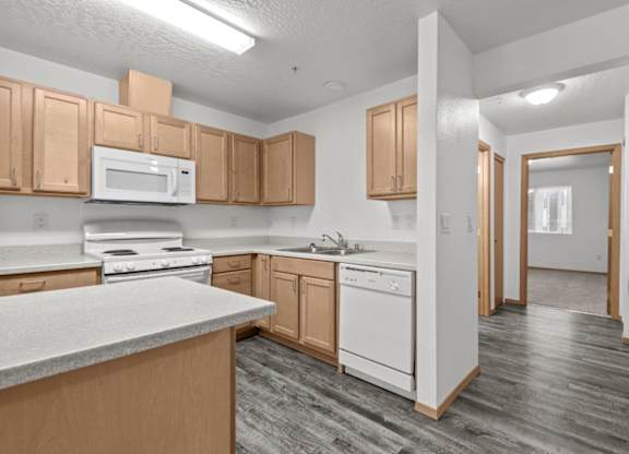A kitchen with wooden cabinets and a white countertop.
