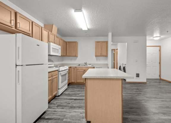 A kitchen with white appliances and wooden cabinets.