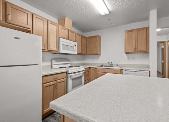 A kitchen with white appliances and wooden cabinets.