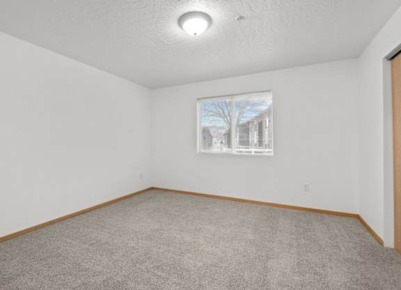 A room with a window and a picture on the wall.
