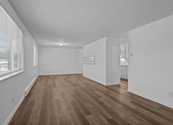 A room with wooden flooring and white walls.
