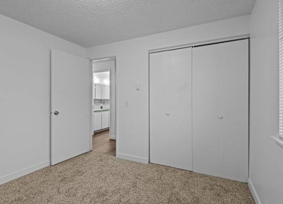 A white room with a carpeted floor and a sliding door.