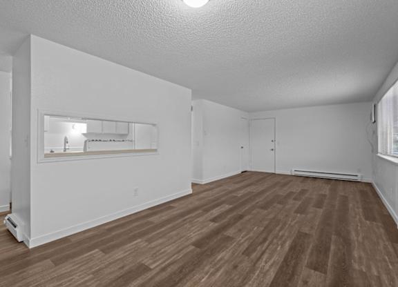 A room with wooden flooring and white walls.