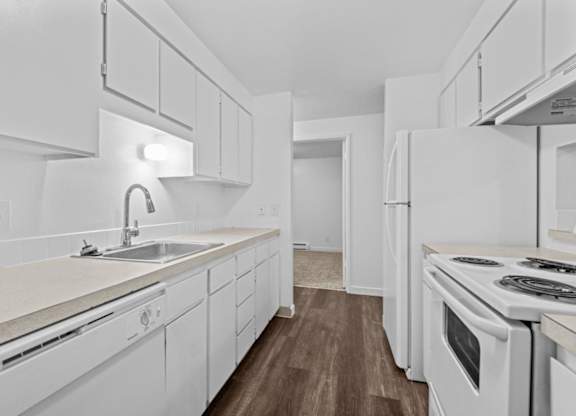 A white kitchen with a sink and a stove.