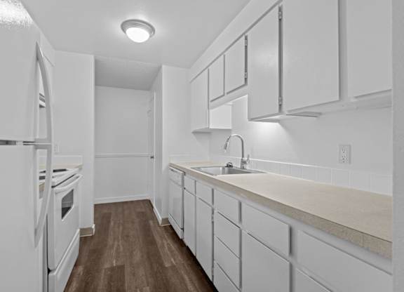 A kitchen with white appliances and cabinets.