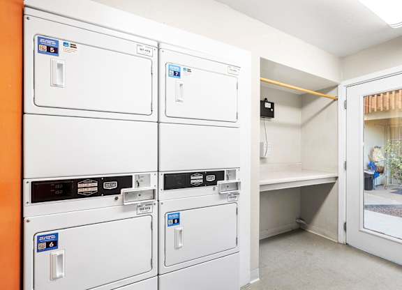 A row of washing machines in a laundry room.