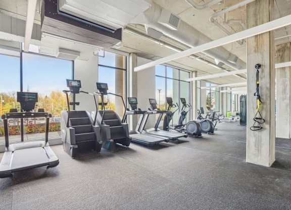 A gym with treadmills, elliptical machines, and other exercise equipment.