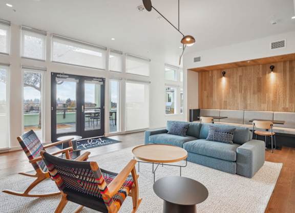 A living room with a blue couch and a wooden rocking chair.