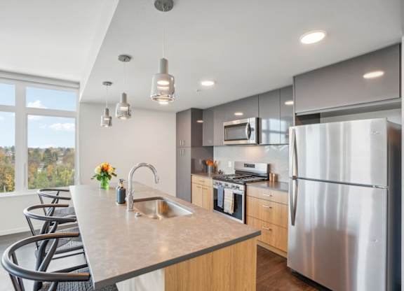A modern kitchen with a large island and stainless steel appliances.