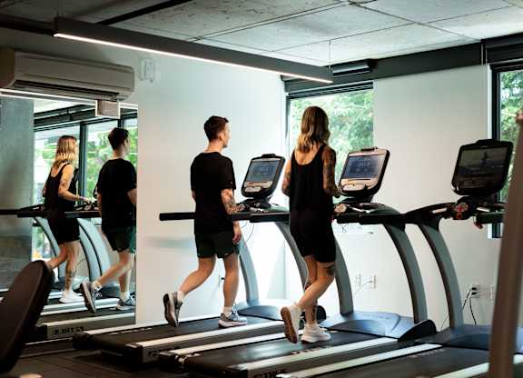 A group of people are exercising on treadmills in a gym.