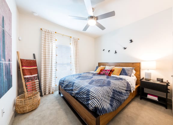 Lenox SoCo Apartments  bedroom with a bed and a ceiling fan