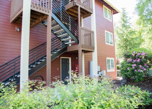 the front of a house with stairs and flowers