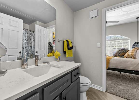 A bathroom with a white sink and a white toilet.