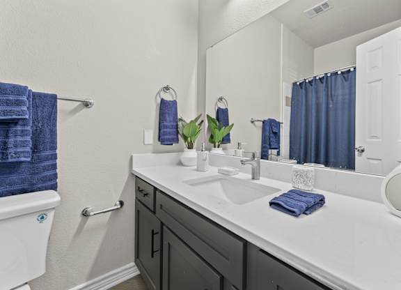 A bathroom with a white sink and a white toilet.