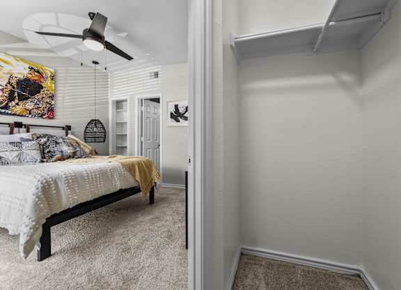 A bedroom with a bed and a ceiling fan.