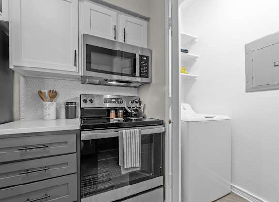 A modern kitchen with a stove, microwave, and oven.