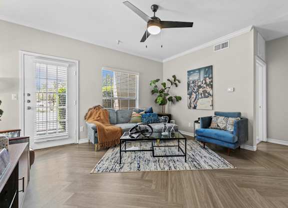 A living room with a blue couch and a rug.