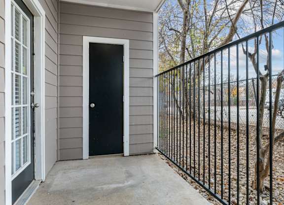 A black door is on the side of a house.