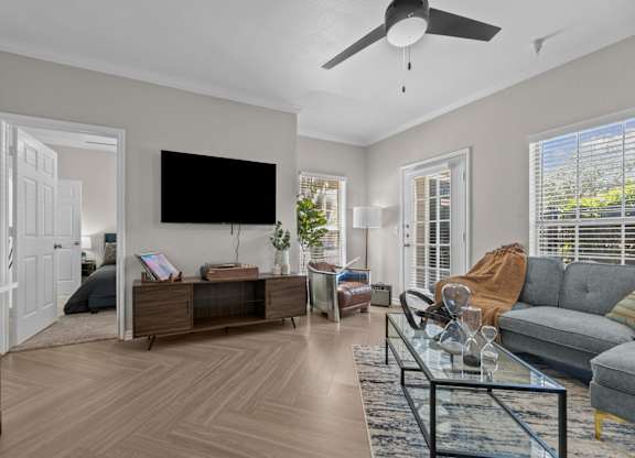 A living room with a flat screen TV mounted on the wall.