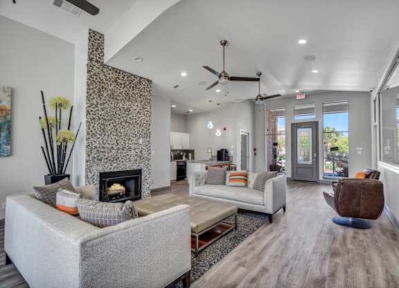 A modern living room with a fireplace and a grey sofa.