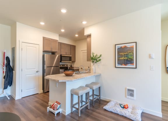 a kitchen with an island and stools in a new home