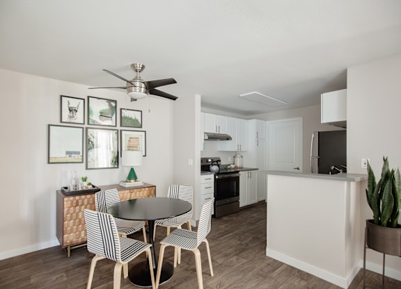 A modern kitchen with a dining table set for four.