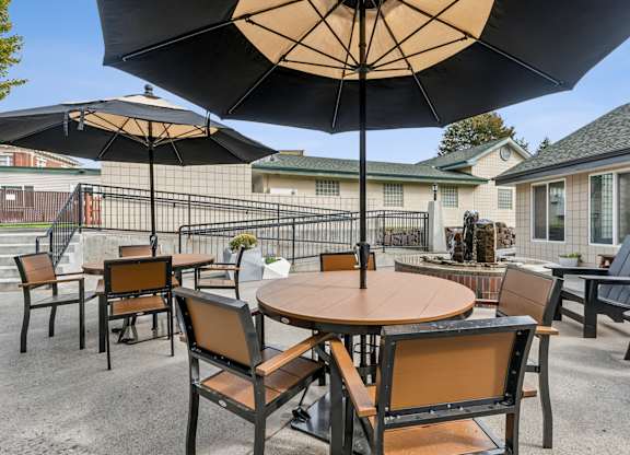A patio with a table and chairs under an umbrella.