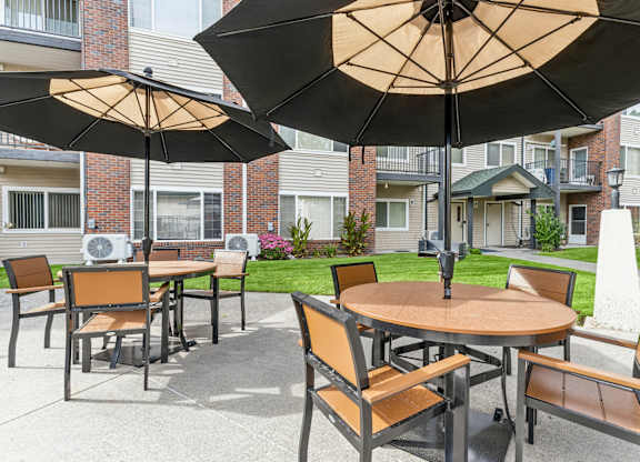 A patio with a table and chairs under an umbrella.